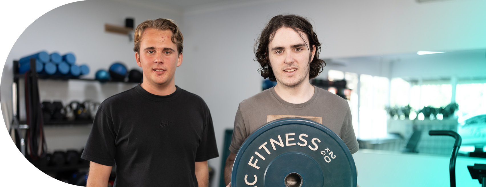 Client Charlie and owner Charlie holding a plate weight at Exercise Therapies