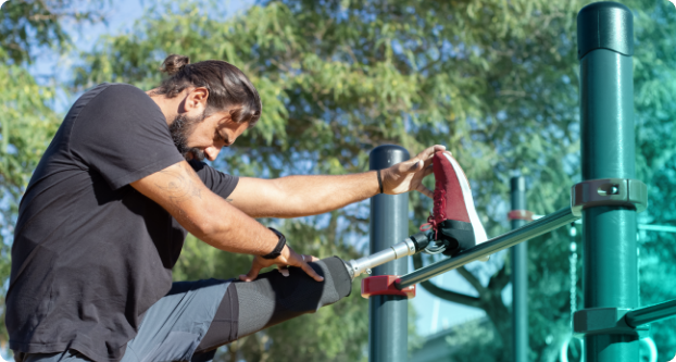 Paraplegic runner with a prosthetic leg stretching his legs with the help of Exercise Therapies