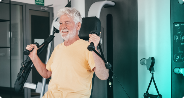 Middle-aged male performing chest press exercise in clinic at Exercise Therapies